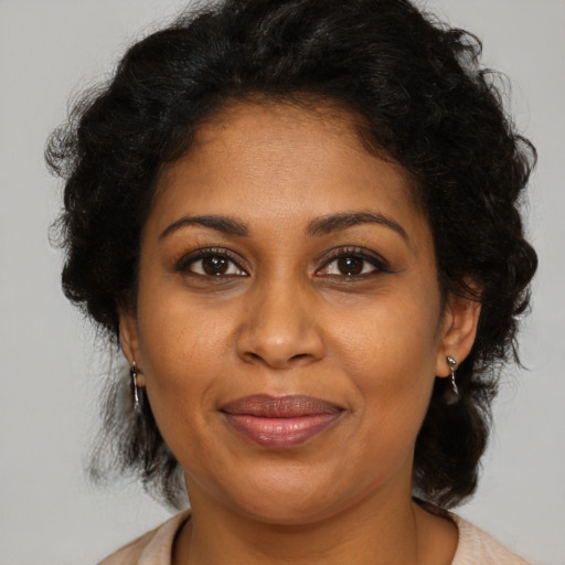 Joyful black adult female with medium  brown hair and brown eyes