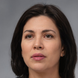 Joyful white adult female with long  brown hair and brown eyes