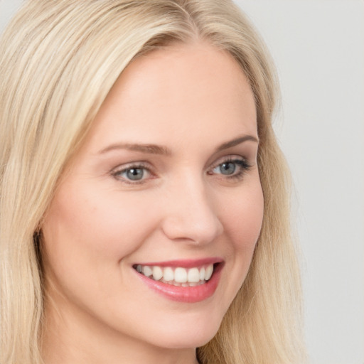 Joyful white young-adult female with long  blond hair and blue eyes