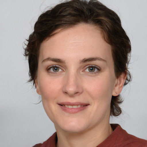 Joyful white young-adult female with medium  brown hair and green eyes