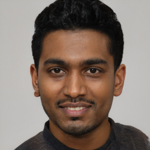 Joyful black young-adult male with short  black hair and brown eyes