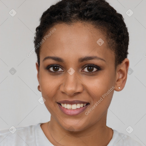 Joyful black young-adult female with short  brown hair and brown eyes