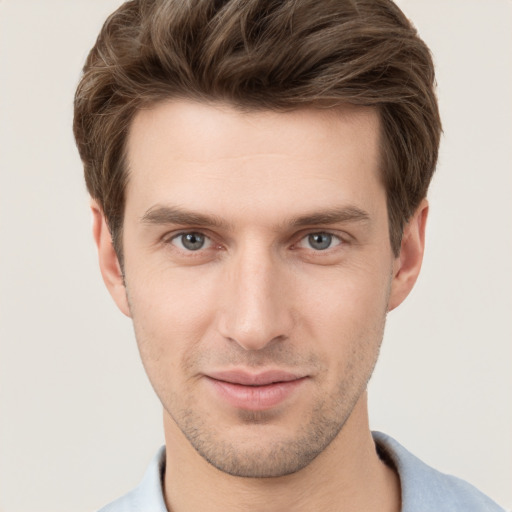 Joyful white young-adult male with short  brown hair and grey eyes