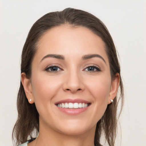 Joyful white young-adult female with medium  brown hair and grey eyes