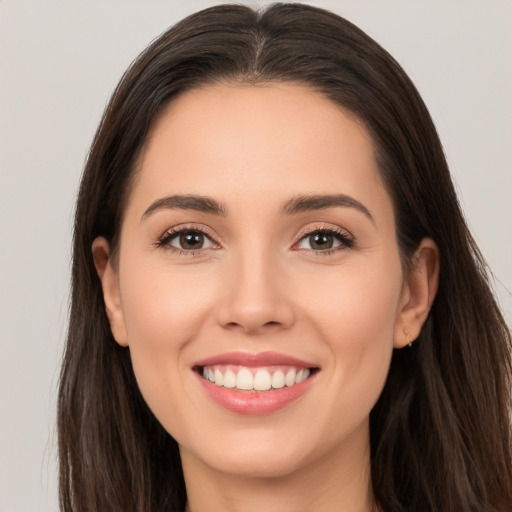 Joyful white young-adult female with long  brown hair and brown eyes