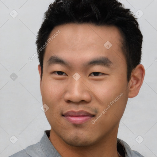 Joyful asian young-adult male with short  black hair and brown eyes