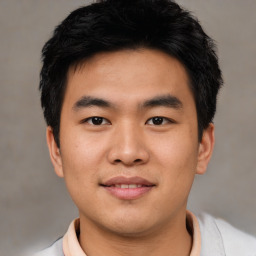 Joyful asian young-adult male with short  black hair and brown eyes