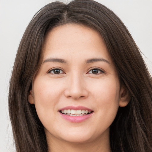 Joyful white young-adult female with long  brown hair and brown eyes