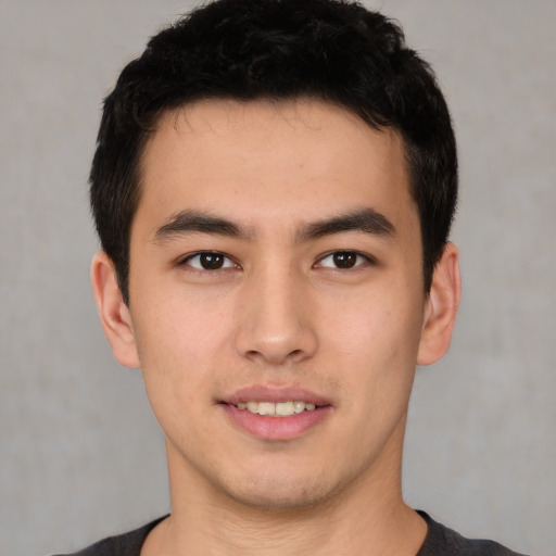 Joyful latino young-adult male with short  brown hair and brown eyes