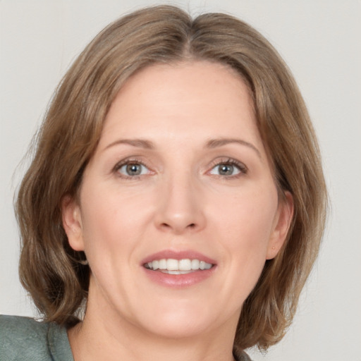 Joyful white adult female with medium  brown hair and grey eyes