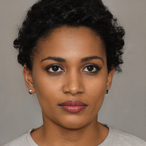 Joyful black young-adult female with short  black hair and brown eyes