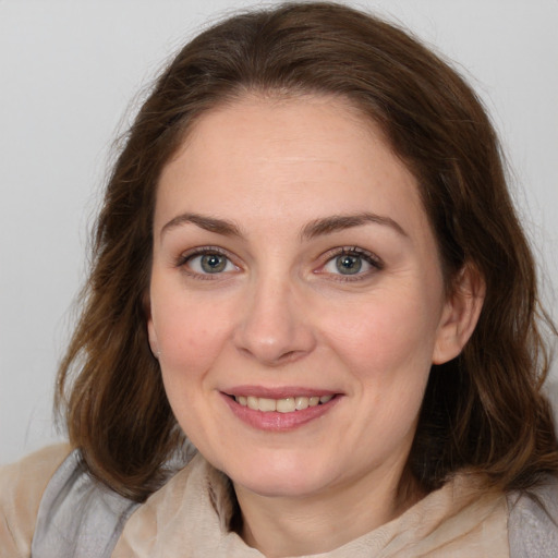 Joyful white adult female with medium  brown hair and brown eyes