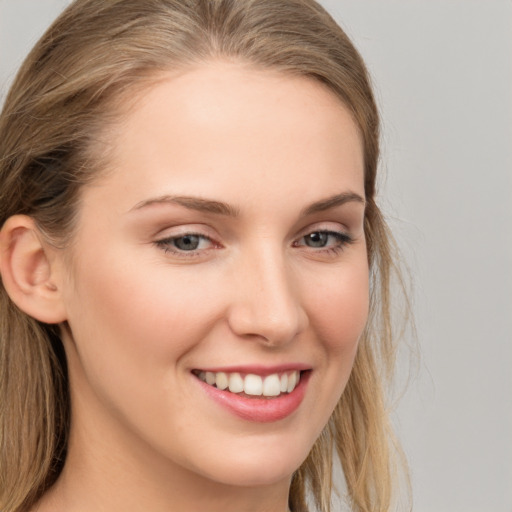 Joyful white young-adult female with long  brown hair and grey eyes