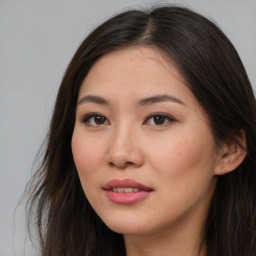 Joyful asian young-adult female with long  brown hair and brown eyes