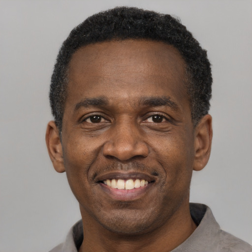 Joyful black adult male with short  black hair and brown eyes