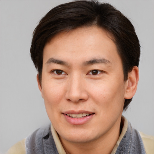 Joyful asian adult male with short  brown hair and brown eyes