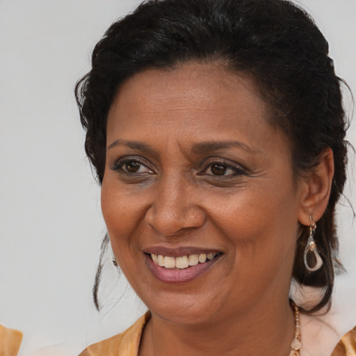 Joyful black adult female with medium  brown hair and brown eyes