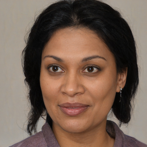Joyful black adult female with medium  brown hair and brown eyes