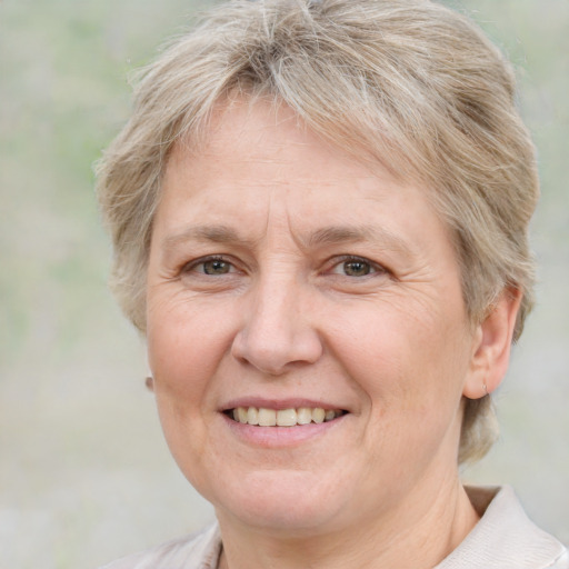 Joyful white middle-aged female with short  blond hair and grey eyes