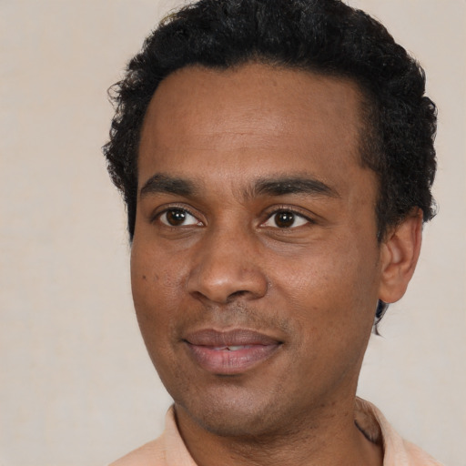 Joyful black young-adult male with short  black hair and brown eyes