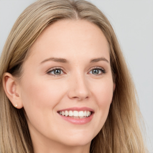 Joyful white young-adult female with long  brown hair and blue eyes