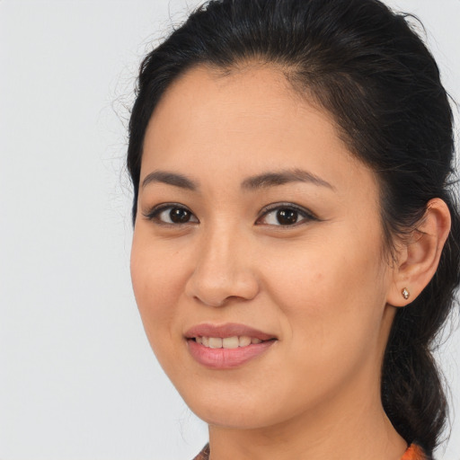 Joyful latino young-adult female with medium  brown hair and brown eyes