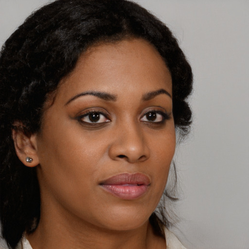 Joyful black young-adult female with medium  brown hair and brown eyes