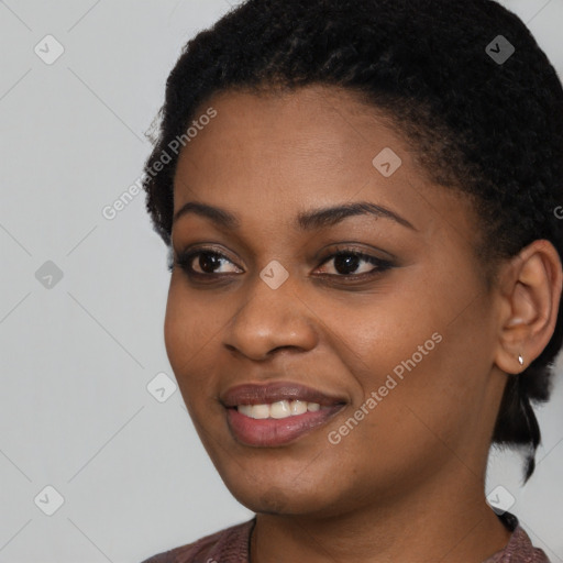 Joyful black young-adult female with short  black hair and brown eyes