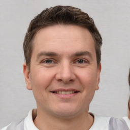 Joyful white young-adult male with short  brown hair and brown eyes