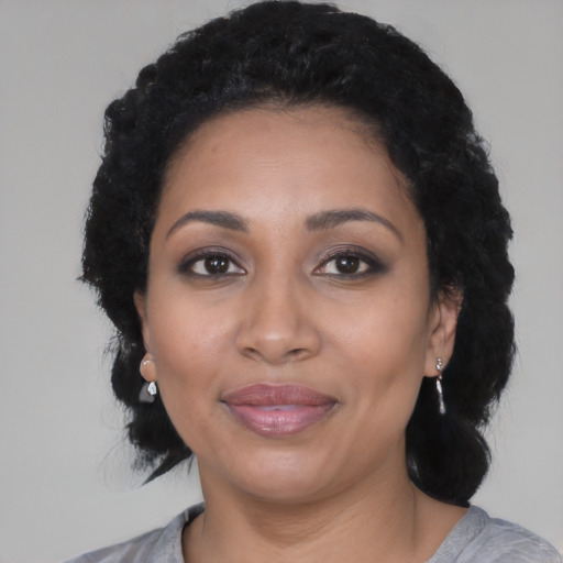 Joyful latino adult female with medium  black hair and brown eyes