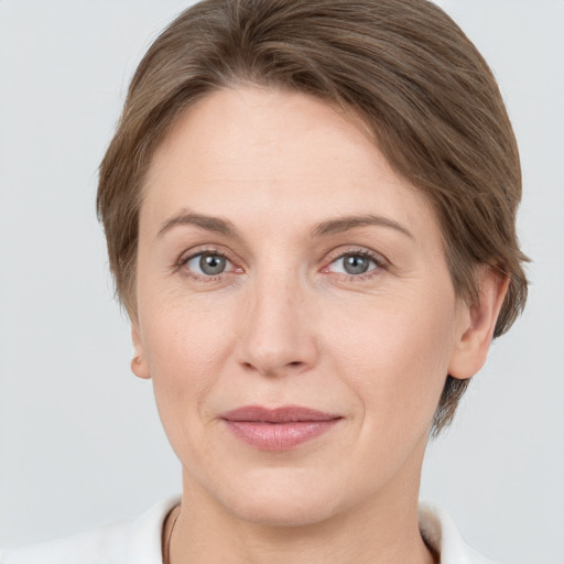 Joyful white young-adult female with short  brown hair and grey eyes