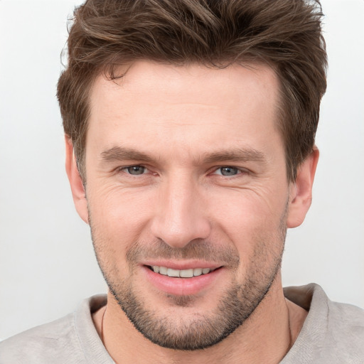 Joyful white young-adult male with short  brown hair and grey eyes