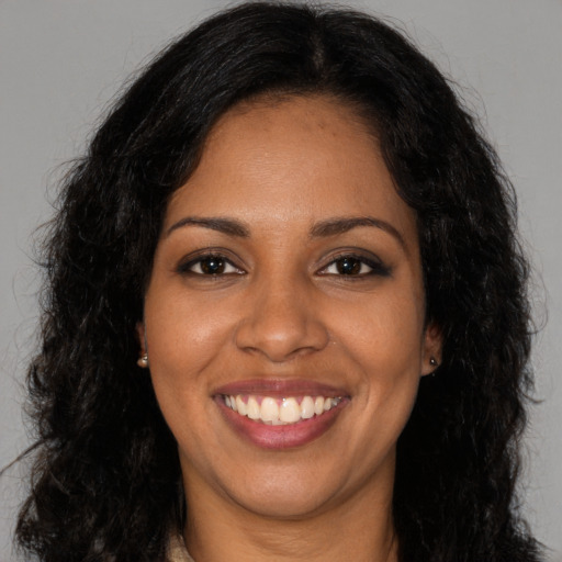 Joyful black adult female with long  brown hair and brown eyes