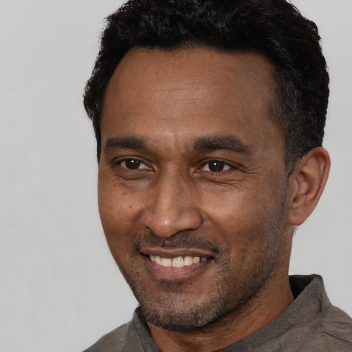 Joyful latino adult male with short  black hair and brown eyes