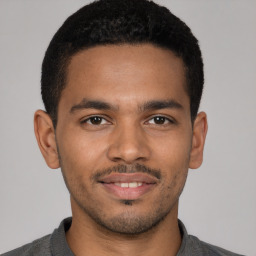 Joyful latino young-adult male with short  brown hair and brown eyes