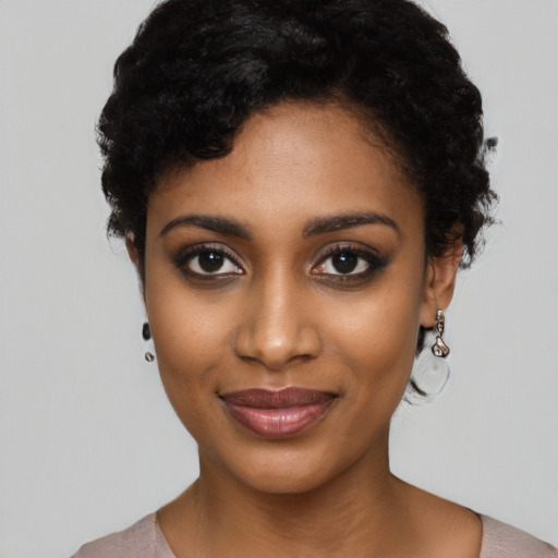 Joyful black young-adult female with short  black hair and brown eyes
