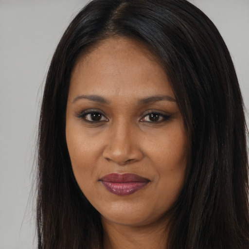 Joyful black young-adult female with long  brown hair and brown eyes
