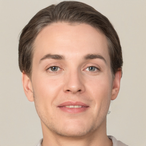 Joyful white young-adult male with short  brown hair and grey eyes