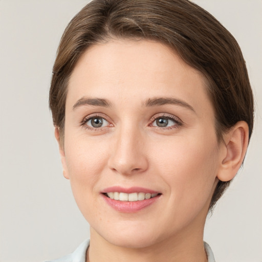 Joyful white young-adult female with short  brown hair and grey eyes