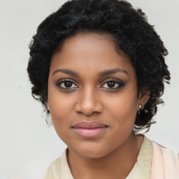 Joyful black young-adult female with long  brown hair and brown eyes