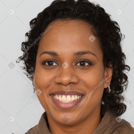 Joyful black adult female with long  brown hair and brown eyes