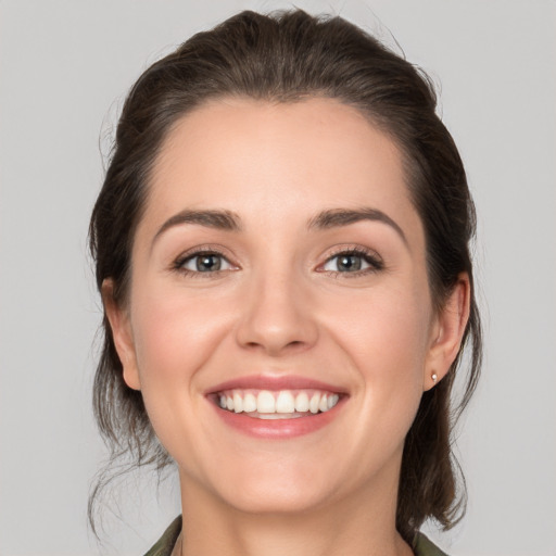 Joyful white young-adult female with medium  brown hair and grey eyes