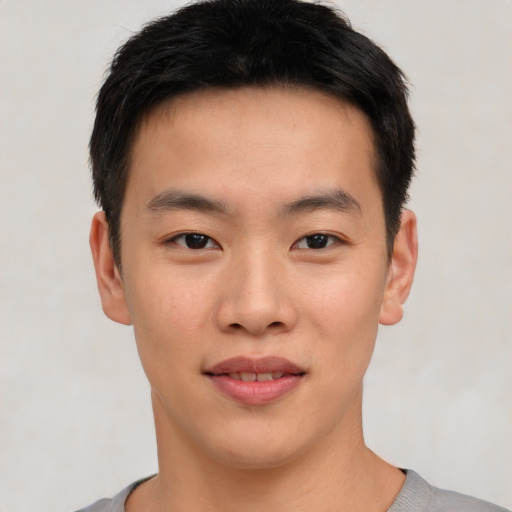 Joyful asian young-adult male with short  black hair and brown eyes