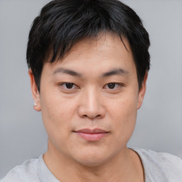 Joyful asian young-adult male with short  black hair and brown eyes