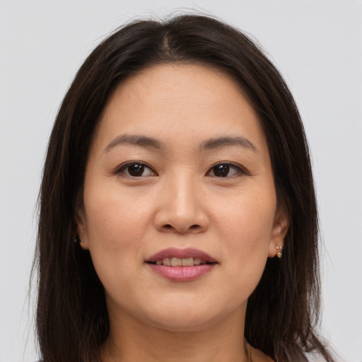 Joyful asian young-adult female with long  brown hair and brown eyes