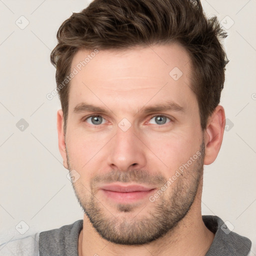 Joyful white young-adult male with short  brown hair and grey eyes