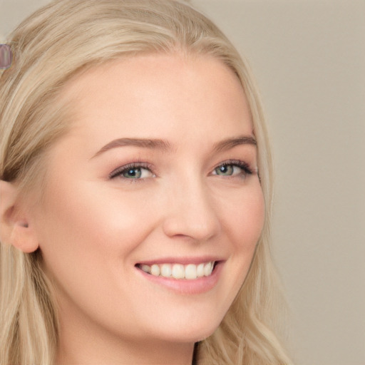 Joyful white young-adult female with long  blond hair and blue eyes