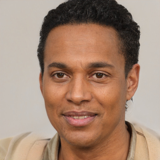 Joyful black young-adult male with short  brown hair and brown eyes