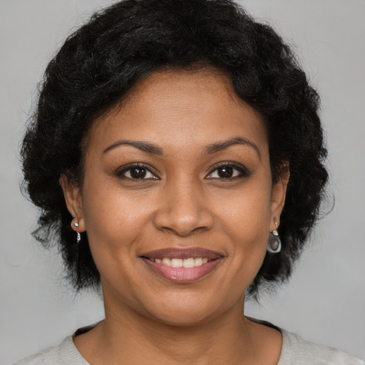 Joyful black young-adult female with short  brown hair and brown eyes