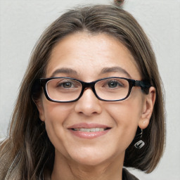 Joyful white adult female with long  brown hair and brown eyes